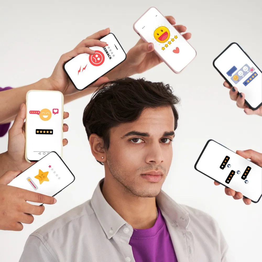Young man surrounded by smartphones displaying customer feedback and emoji ratings, symbolizing social media influence on brand perception